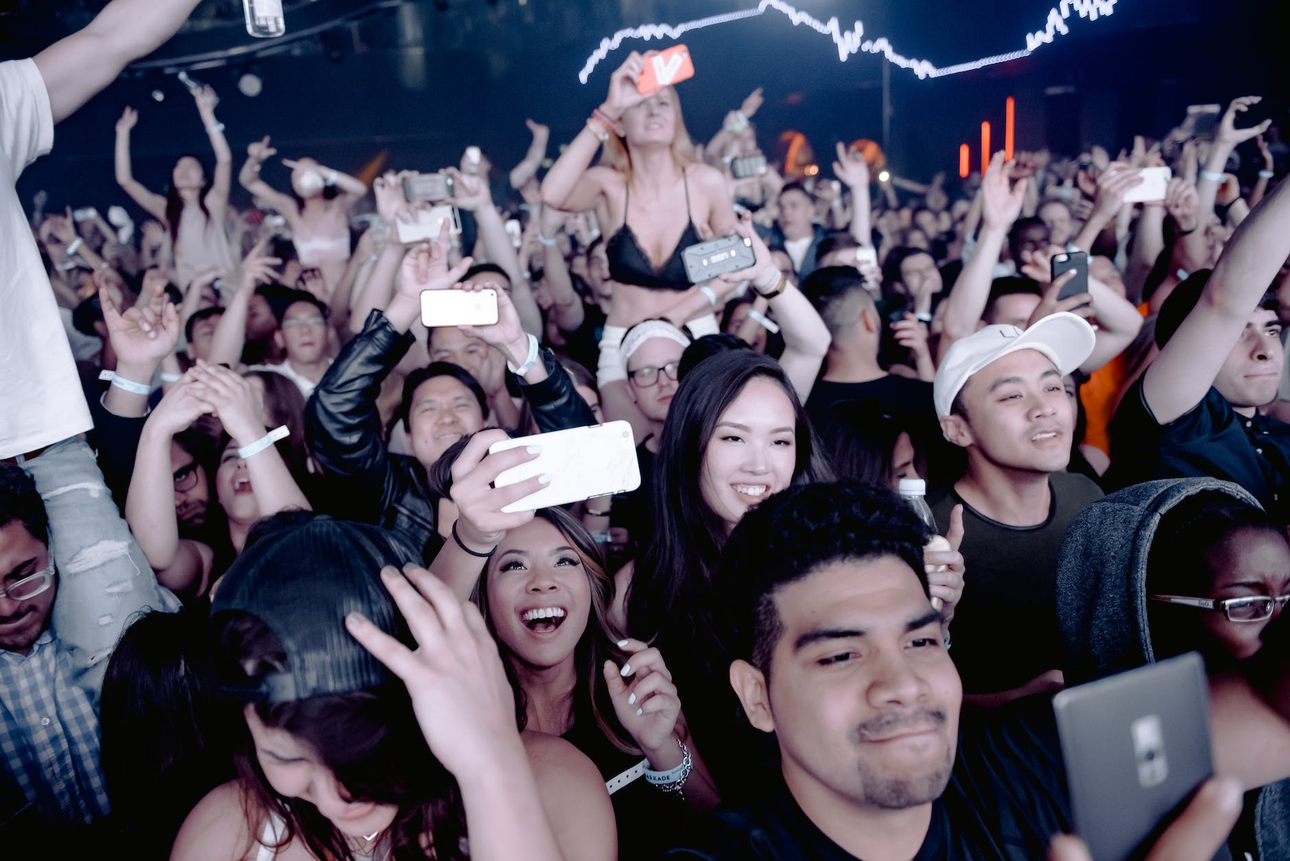 Concert-goers watching the perforamce through a smarphone