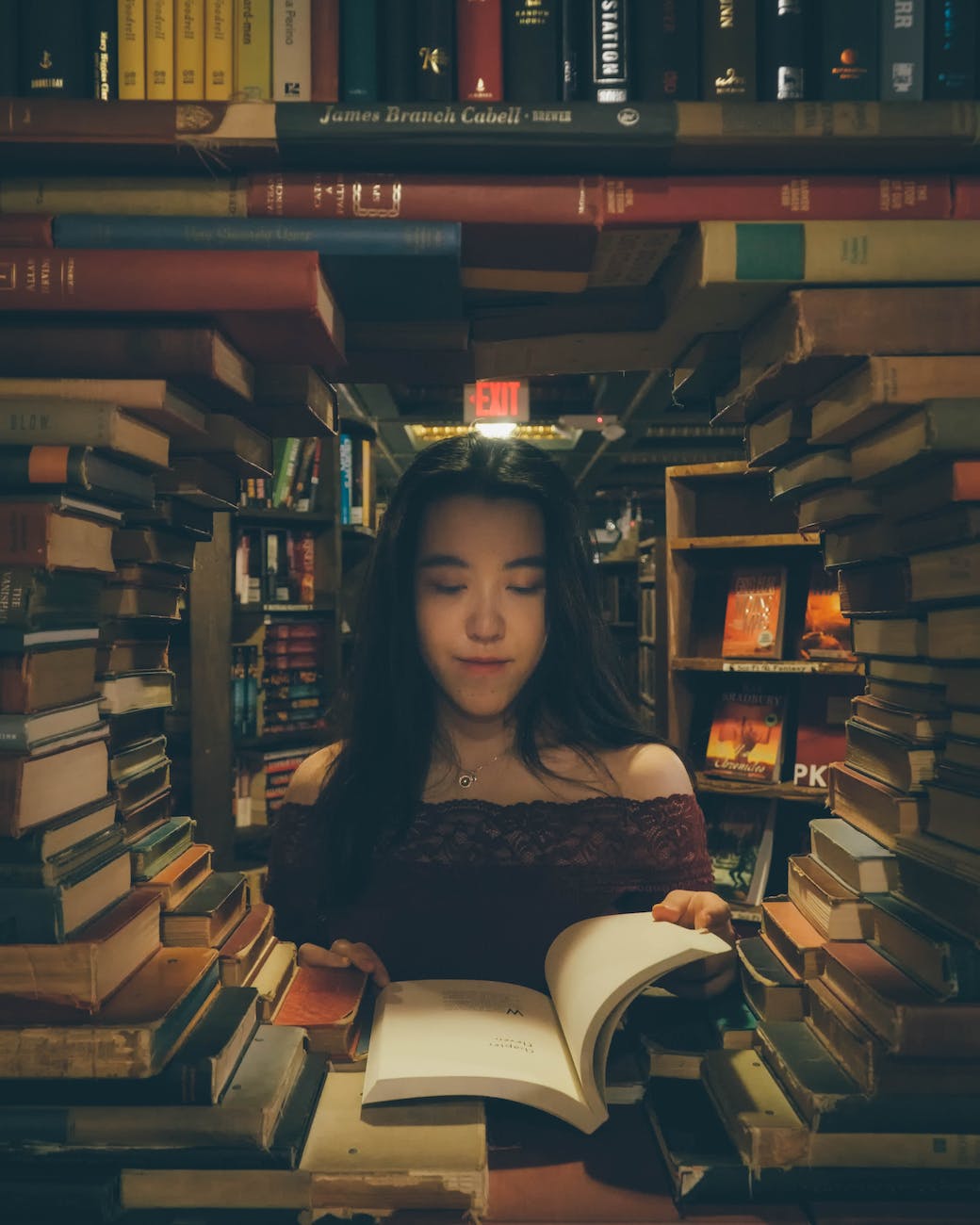 young woman reading a book in a library