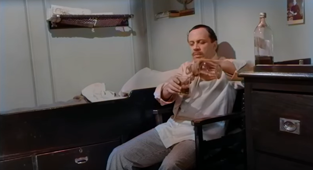 A still from the movie, A Night to Remember. The character, Charles John Joughin enjoys a drink in his room while the ship is sinking